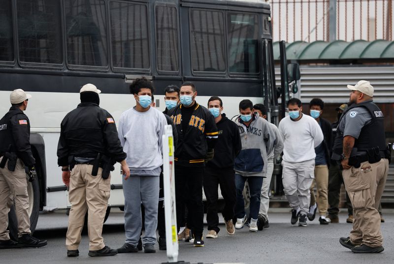 FILE PHOTO: Migrants are escorted across the Hidalgo International Bridge as they are deported after crossing into the U.S. without authorization, in McAllen, Texas, U.S., January 27, 2025. REUTERS/Daniel Becerril/File Photo