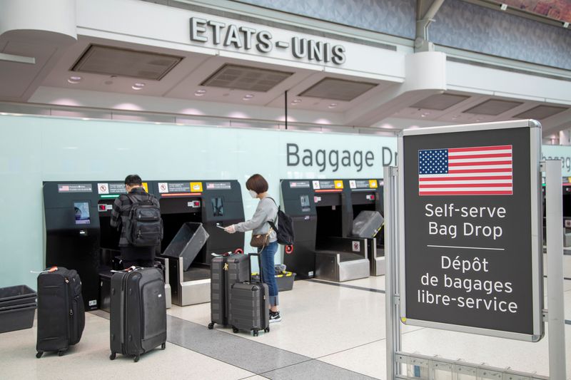 FILE PHOTO: Passengers drop their bags off before walking towards the gates for U.S. travel at Toronto Pearson International Airport in Toronto, Ontario, Canada June 23, 2020.  REUTERS/Carlos Osorio/File Photo