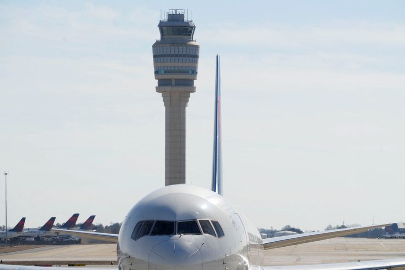 Atlanta's air traffic control tower is seen behind a plane at Hartsfield-Jackson Atlanta International Airport, in Georgia, U.S. February 1, 2025.  REUTERS/Megan Varner/File Photo