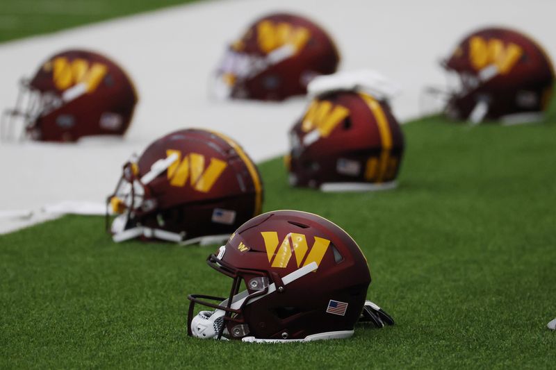 FILE PHOTO: May 6, 2022; Ashburn, Virginia, USA; Washington Commanders players' helmets rest on the field during Washington Commanders rookie minicamp at Inova Performance Center In Ashburn, VA. Mandatory Credit: Geoff Burke-USA TODAY Sports/File Photo
