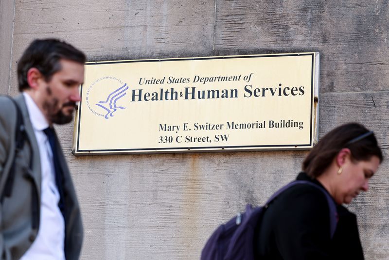 FILE PHOTO: Employees of the Department of Health and Human Services (HHS) stand outside the Mary E. Switzer Memorial Building, in Washington, D.C., U.S., April 1, 2025. REUTERS/Kevin Lamarque/File Photo