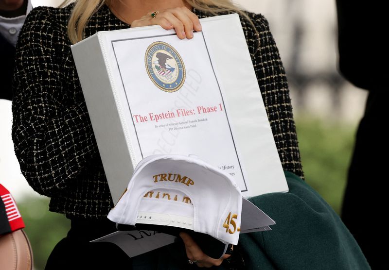 FILE PHOTO: People walk out of the West Wing of the White House with "The Epstein Files: Phase 1" binders, in Washington, D.C., U.S., February 27, 2025. REUTERS/Kevin Lamarque/File Photo