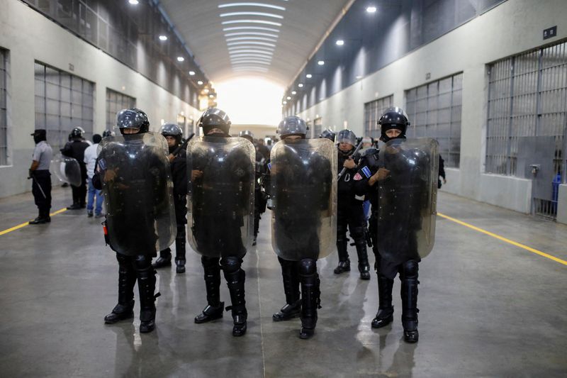 FILE PHOTO: Police officers stand guard during a media tour at the Terrorism Confinement Center (CECOT) prison, in Tecoluca, El Salvador April 4, 2025. REUTERS/Jose Cabezas/File Photo
