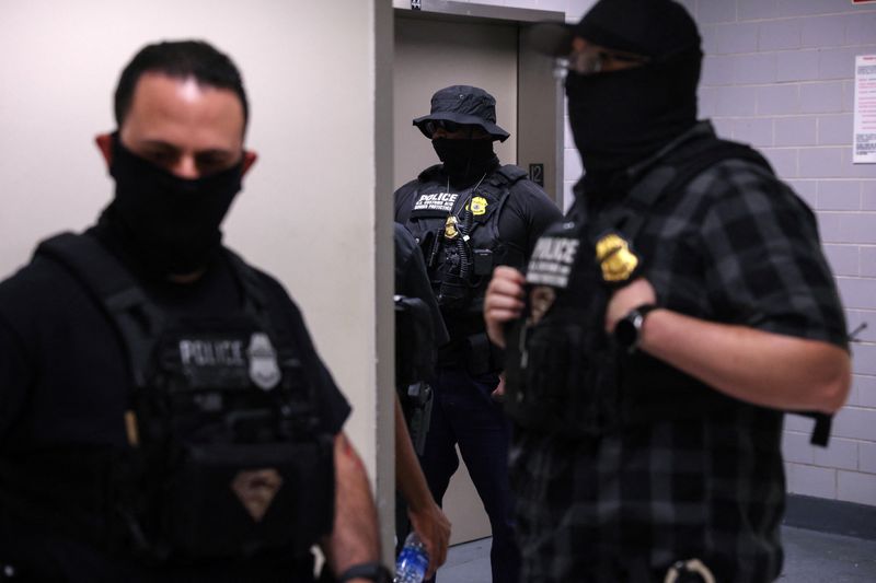 FILE PHOTO: Federal immigration officers stand with masks, as federal detainments continue, in the hallways of U.S. immigration court in New York City, U.S., August 19, 2025. REUTERS/Shannon Stapleton/File photo
