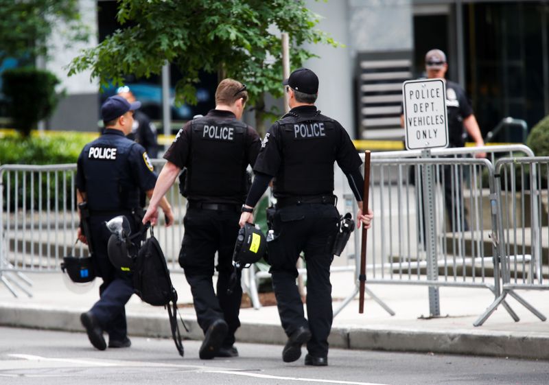 FILE PHOTO: Seattle Police officers carry gear as they walk towards the Seattle Police Department's West Precinct in Seattle, Washington, U.S. June 10, 2020. REUTERS/Lindsey Wasson/ File Photo