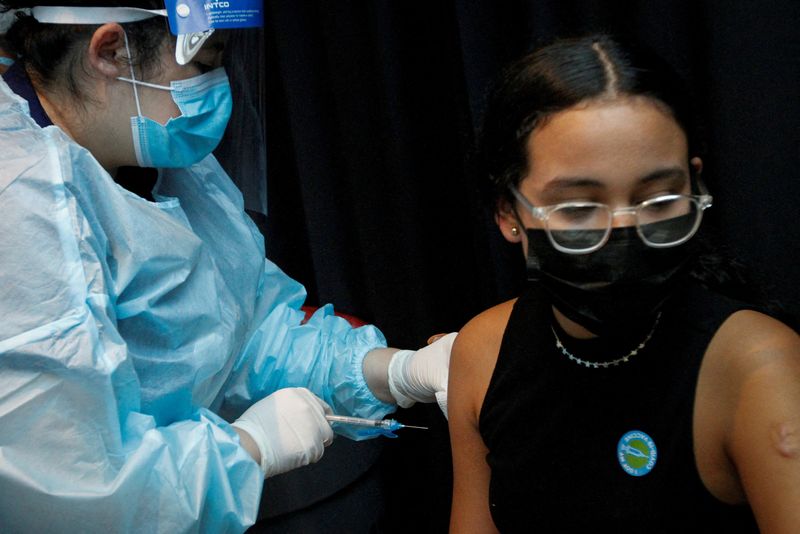 FILE PHOTO: A girl is inoculated against the coronavirus disease (COVID-19) during a vaccination event hosted by Miami-Dade County and Miami Heat, at FTX Arena in Miami, Florida, U.S., August 5, 2021. REUTERS/Marco Bello/File Photo