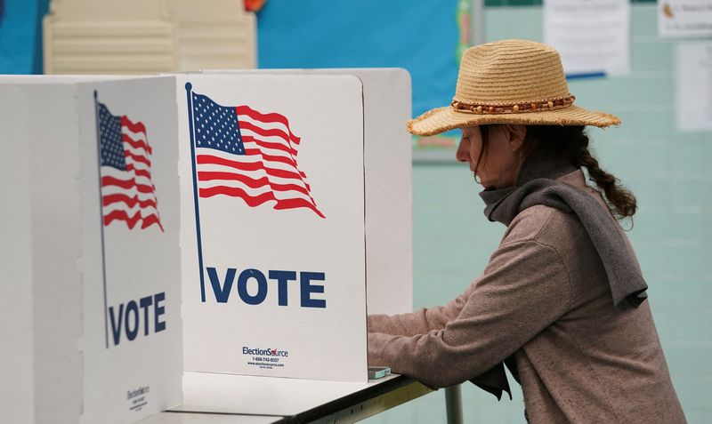 A voter casts her ballot at a polling station on Election Day in Falls Church, Virginia, U.S., November 7, 2023. REUTERS/Kevin Lamarque