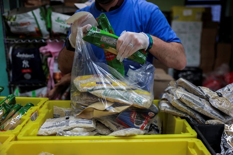 A volunteer puts food items into a bag at a New York Common Pantry distribution site, in the Bronx borough of New York City, U.S., August 20, 2025. REUTERS/Jeenah Moon/File Photo