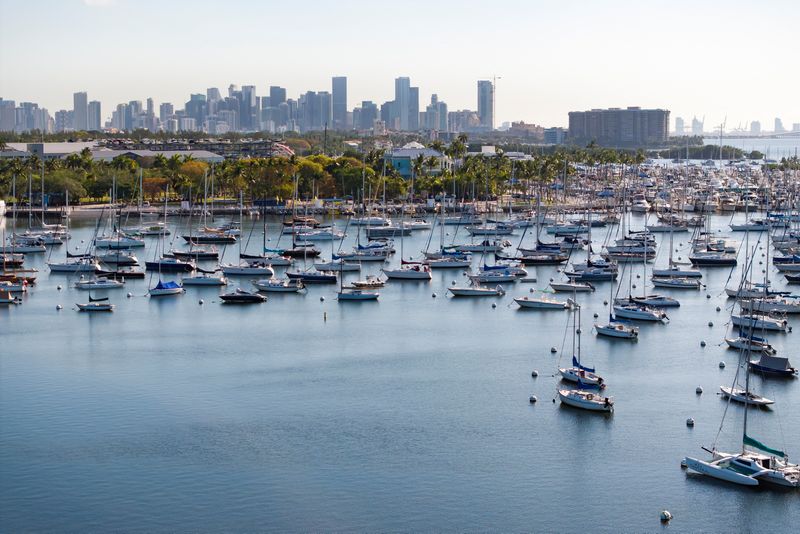 A drone view shows sailboats moored next to the Coconut Grove Sailing Club and the downtown skyline in Miami, Florida, U.S. April 16, 2025. REUTERS/Marco Bello