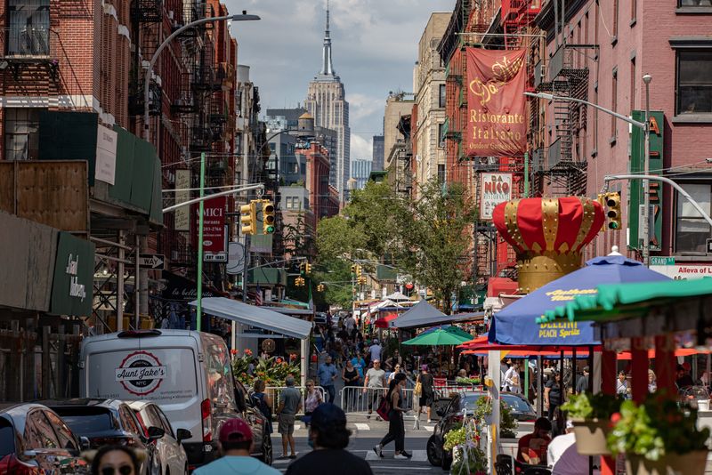 People walk down a street lined with outdoor seating for restaurants in the Little Italy neighborhood of Manhattan, in New York City, New York, U.S., July 18, 2021. REUTERS/Jeenah Moon