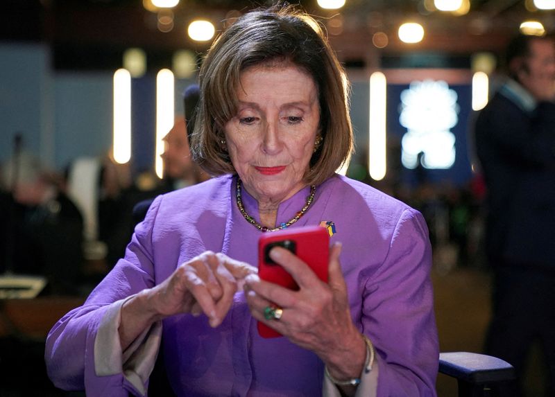 FILE PHOTO: U.S. House Speaker Nancy Pelosi looks at her phone, as she attends the COP27 climate summit, in Sharm el-Sheikh, Egypt, November 11, 2022. REUTERS/Kevin Lamarque/File Photo