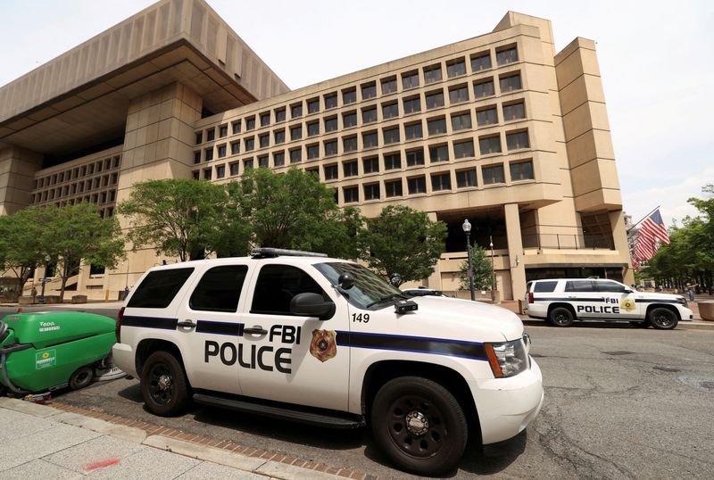 FILE PHOTO: FBI police vehicles are parked in front of the J. Edgar Hoover Building on the day that FBI Director Kash Patel announced that he’s redeploying 1,500 FBI agents and shutting down the bureau’s storied headquarters, in Washington, D.C., U.S., May 16, 2025. REUTERS/Kevin Lamarque/File Photo