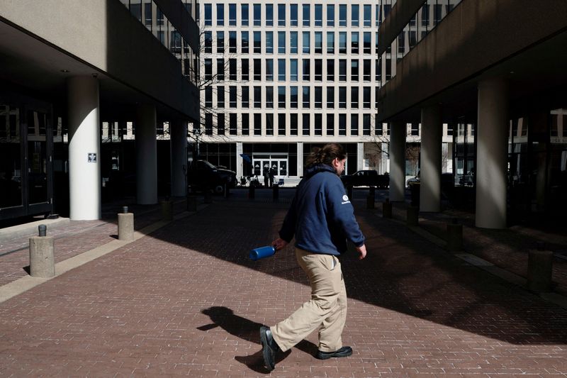 FILE PHOTO: A pedestrian walks past the U.S. Department of Education headquarters after the agency said it would lay off nearly half its staff, a possible precursor to closing altogether, as government agencies scrambled to meet President Donald Trump's deadline to submit plans for a second round of mass layoffs, in Washington, D.C., U.S., March 12, 2025. REUTERS/Nathan Howard/File Photo