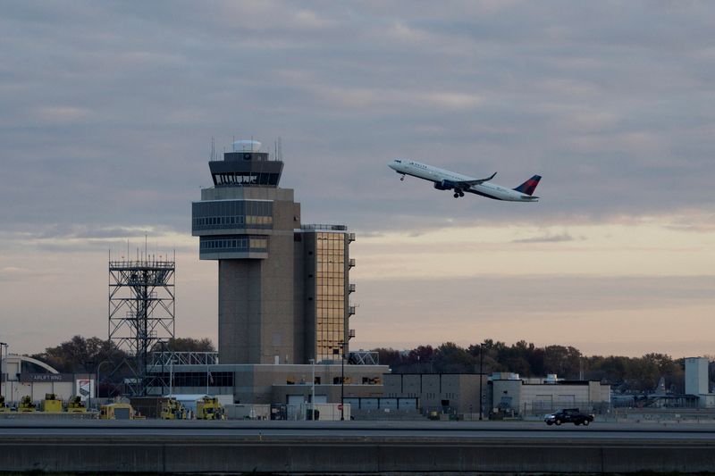 A plane passes an air traffic control tower during takeoff at Minneapolis–Saint Paul International Airport in Minneapolis, Minnesota, U.S., November 7, 2025.  REUTERS/Tim Evans