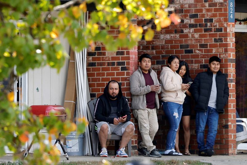 Residents of a largely Hispanic neighbourhood watch a gathering of fellow community members and activists across the street from the site of a concluded raid by federal authorities as they expand their crackdown on illegal immigration, in Raleigh, North Carolina, U.S., November 18, 2025.  REUTERS/Jonathan Drake