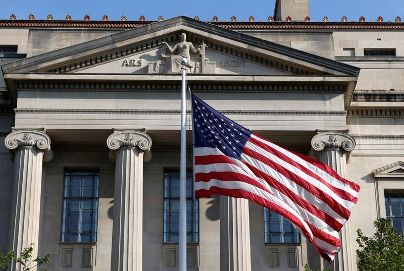FILE PHOTO: A flag flies outside the Department of Justice building in Washington, D.C., U.S., September 23, 2025. REUTERS/Kevin Lamarque/File Photo