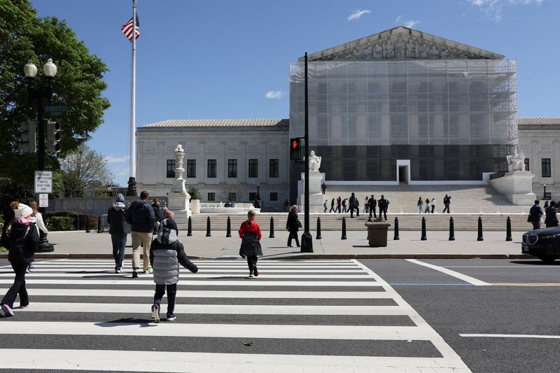 People walk near the U.S. Supreme Court building in Washington, D.C., U.S., April 8, 2025. REUTERS/Jonathan Ernst
