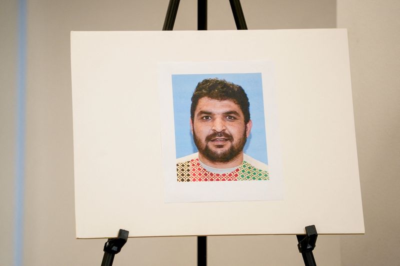 A picture of Rahmanullah Lakanwal, an Afghan national who is the suspect in the shooting of two National Guard members, is displayed at a press conference with FBI Director Kash Patel, attorney Jeanine Pirro and other authorities, in Washington, D.C., U.S., November 27, 2025. REUTERS/Nathan Howard