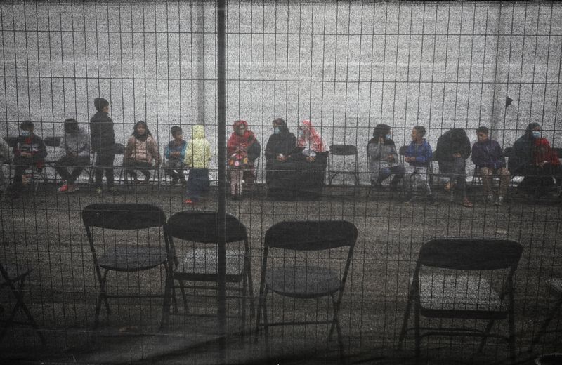 Afghan refugees queue outside a distribution and donation center at Liberty Village on Joint Base McGuire-Dix-Lakehurst in New Jersey, U.S., December 2, 2021.  REUTERS/Barbara Davidson/Pool