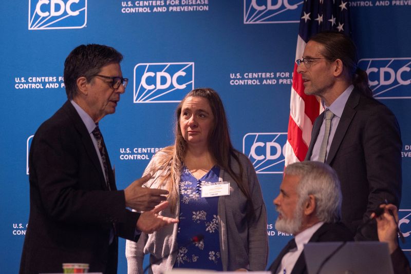 Dr. James Pagano, Case Western Reserve University Professor Catherine Stein, and Massachusetts Institute of Technology professor Retsef Levi talk amongst themselves during a meeting of the Advisory Committee on Immunization Practices (ACIP) to discuss childhood vaccine schedule, at the Centers for Disease Control and Prevention in Atlanta, Georgia, U.S., December 5, 2025. REUTERS/Alyssa Pointer
