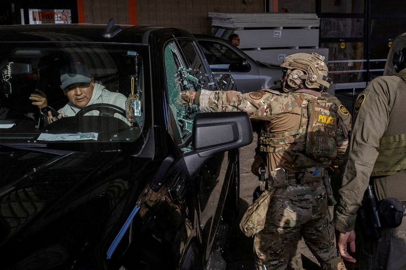FILE PHOTO: U.S. federal agents smash a car window while trying to detain a man during an immigration raid, after U.S. President Donald Trump ordered increased federal law enforcement presence to assist in crime prevention, in Chicago, Illinois, U.S., December 17, 2025. REUTERS/Jim Vondruska/File Photo