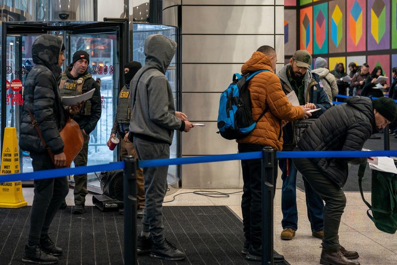 Immigration Customs Enforcement (I.C.E.) agents check the paperwork of respondents arriving at U.S. immigration court in Manhattan, New York City, U.S., December 15, 2025. REUTERS/David 'Dee' Delgado