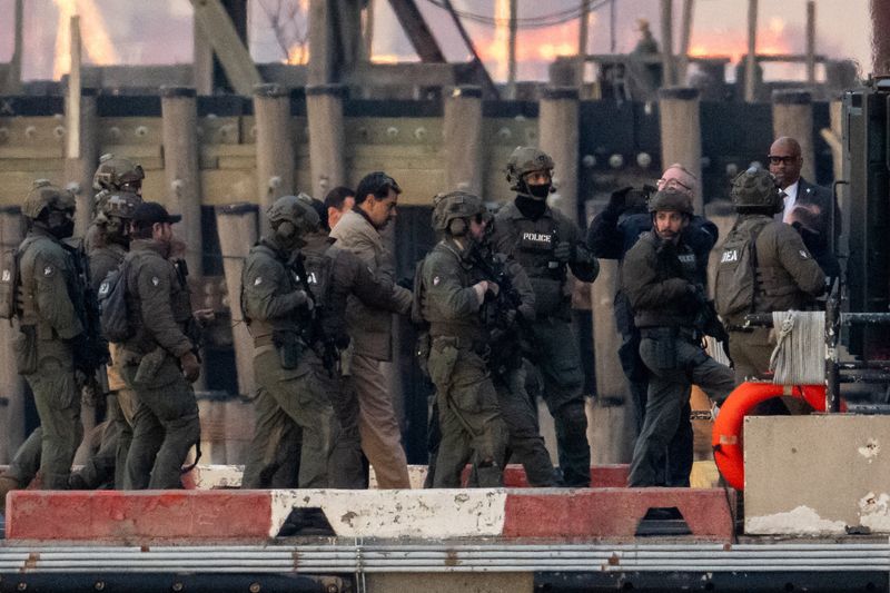 Captured Venezuelan President Nicolas Maduro is escorted, as he heads towards the Daniel Patrick Moynihan United States Courthouse in Manhattan for an initial appearance to face U.S. federal charges including narco-terrorism, conspiracy, drug trafficking, money laundering and others, at Downtown Manhattan Heliport, in New York City, U.S., January 5, 2026. REUTERS/Adam Gray