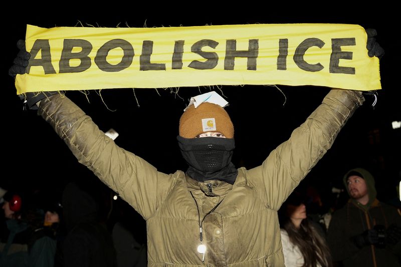 A person holds a banner as people march during a demonstration against increased immigration enforcement, days after the fatal shooting of Renee Nicole Good by a U.S. Immigration and Customs Enforcement (ICE) agent, in Minneapolis, Minnesota, U.S., January 9, 2026.  REUTERS/Tim Evans/File Photo