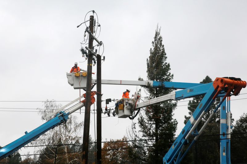 PG&E crew work on power lines to repair damage caused by the Camp Fire in Paradise, California, U.S. November 21, 2018.  REUTERS/Elijah Nouvelage