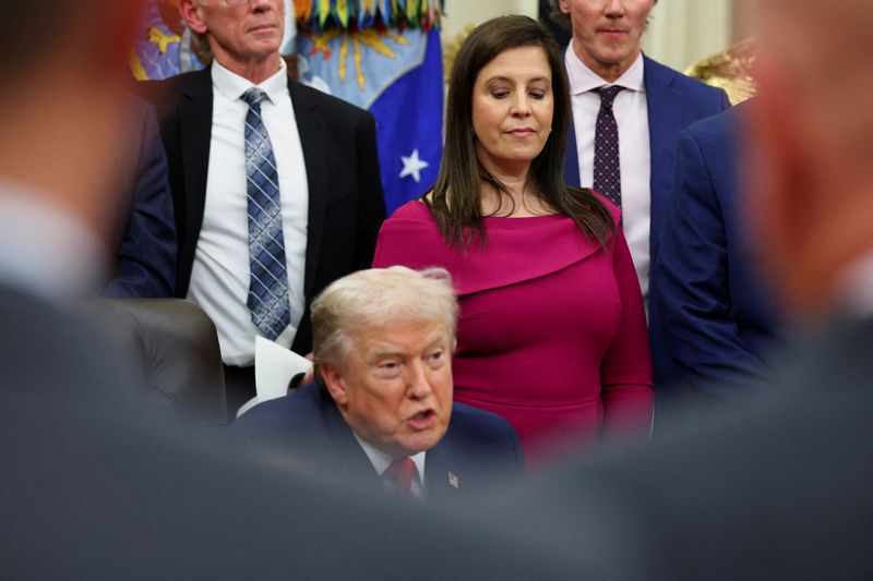 FILE PHOTO: U.S. Representative Elise Stefanik looks at U.S. President Donald Trump as he speaks on the day he signs a bill to award congressional gold medals to members of the 1980 U.S. Olympic men's hockey team, who went on to win gold after defeating a heavily-favored Soviet Union team in their "Miracle on Ice" medal-round match, in the Oval Office at the White House in Washington, D.C., U.S. December 12, 2025. REUTERS/Jonathan Ernst/File Photo
