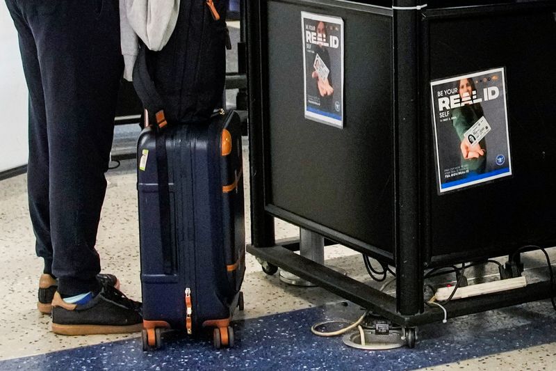 A Real ID signage is displayed as a passenger shows his Real ID in a check point at Newark International Airport in Newark, New Jersey, U.S., May 7, 2025. REUTERS/Eduardo Munoz