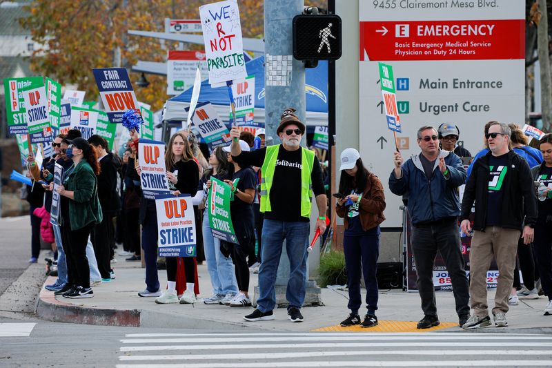 Striking members of the United Nurses Associations of California and Union of Health Care Professionals hold signs along the picket line outside a Kaiser Permanente hospital in San Diego, California, U.S., January 26, 2026. REUTERS/Mike Blake