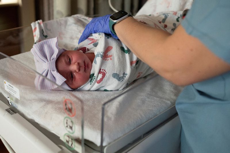 FILE PHOTO: A nurse checks the vitals of a newborn baby in the Family Birth Center at Beaumont Hospital in Royal Oak, Michigan, U.S., February 1, 2022.  REUTERS/Emily Elconin/File Photo