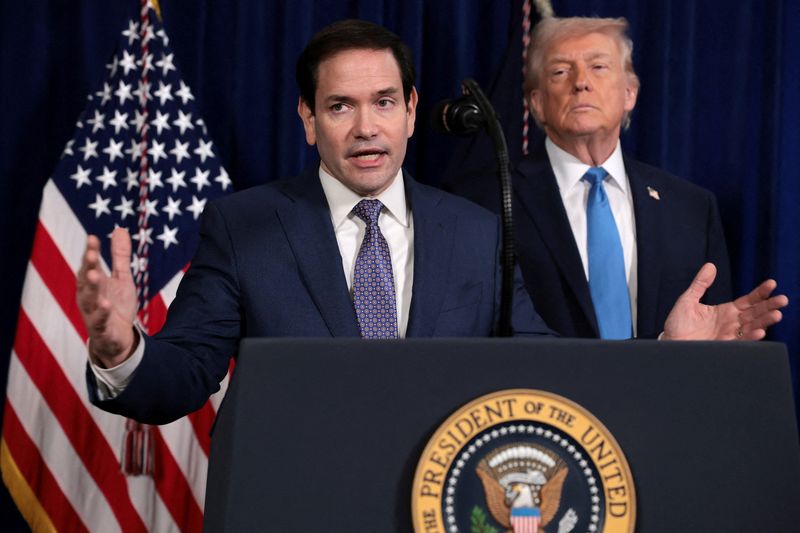 FILE PHOTO: U.S. Secretary of State Marco Rubio speaks as U.S. President Donald Trump stands behind him during a press conference following a U.S. strike on Venezuela where President Nicolas Maduro and his wife, Cilia Flores, were captured, from Trump's Mar-a-Lago club in Palm Beach, Florida, U.S., January 3, 2026. REUTERS/Jonathan Ernst/File Photo