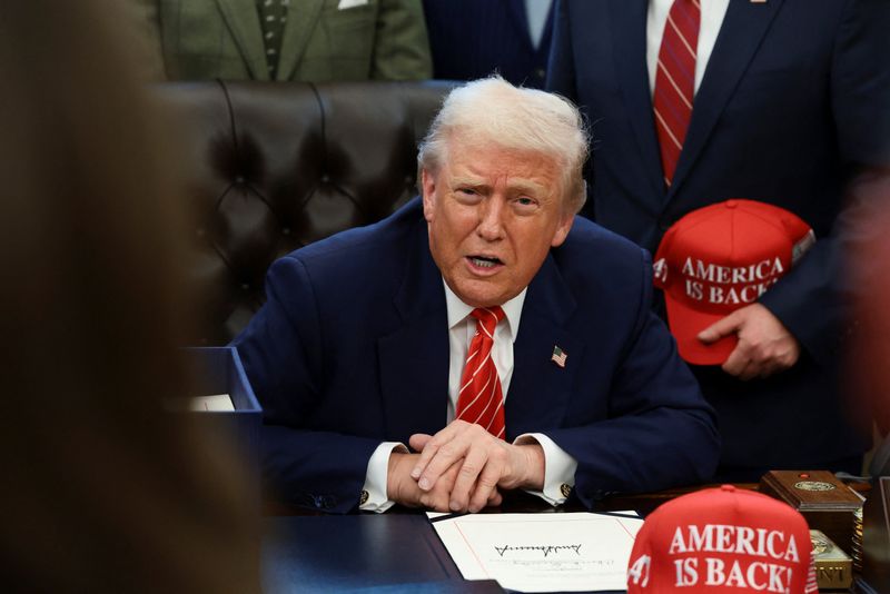 U.S. President Donald Trump sits behind a bill he signed to end the partial government shutdown, at the White House in Washington, D.C., U.S., February 3, 2026. REUTERS/Evelyn Hockstein