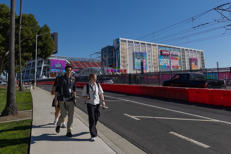 People walk near Levi's Stadium ahead of the Super Bowl LX game between the New England Patriots and the Seattle Seahawks in Santa Clara, California, U.S., February 3, 2026. REUTERS/Carlos Barria