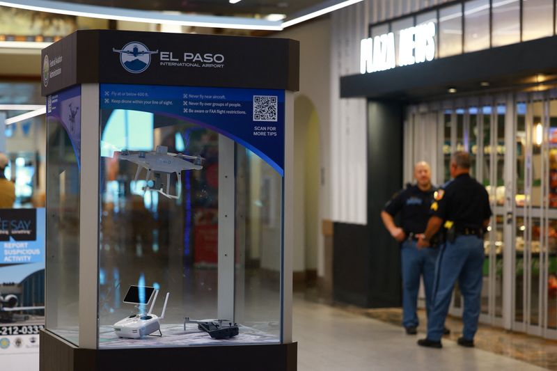 Police officers stand near an exhibition of U.S. Federal Aviation Administration (FAA) drones, at El Paso International Airport, after the FAA lifted its temporary closure of the airspace over El Paso, saying all flights will resume as normal and that there was no threat to commercial aviation, in El Paso, Texas, U.S., February 11, 2026. REUTERS/Jose Luis Gonzalez