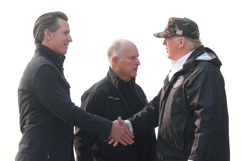 FILE PHOTO: U.S. President Donald Trump shakes hands with Governor-elect Gavin Newsom (L) after greeting Governor Jerry Brown (C) upon arriving at Beale Air Force Base, California, U.S., November 17, 2018. REUTERS/Leah Millis/File Photo