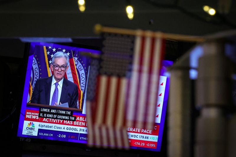 FILE PHOTO: A screen broadcasts a news conference by U.S. Federal Reserve Chair Jerome Powell following the Fed rate announcement, on the floor of the New York Stock Exchange (NYSE) in New York City, U.S., December 10, 2025. REUTERS/Brendan McDermid/File Photo