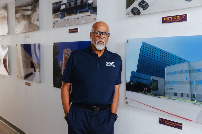 Gregory Cody, President of GCC Enterprises, stands next to photos of projects he’s completed at his office in Dallas, Texas, U.S., March 16, 2026. REUTERS/Shelby Tauber