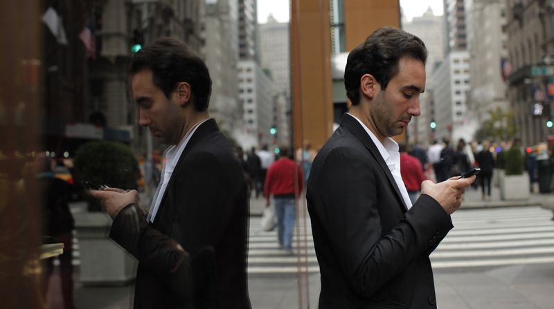 A man types on his mobile phone in New York October 24, 2012. REUTERS/Eduardo Munoz