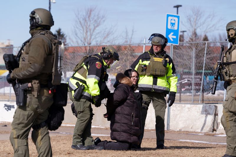 Local law enforcement detain a protester after declaring an unlawful assembly during a demonstration against ongoing Immigration and Customs Enforcement (ICE) operations outside the Whipple Federal Building, in Fort Snelling, Minnesota, U.S., March 1, 2026. REUTERS/Tim Evans
