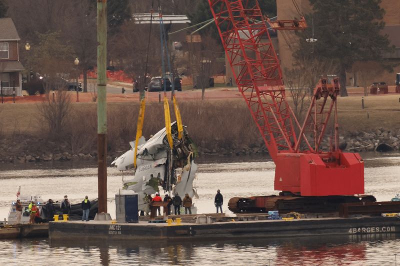 FILE PHOTO: A crane retrieves part of the wreckage from the Potomac River, in the aftermath of the collision of American Eagle flight 5342 and a Black Hawk helicopter that crashed into the river, by the Ronald Reagan Washington National Airport, in Arlington, Virginia, U.S., February 3, 2025. REUTERS/Eduardo Munoz/File Photo
