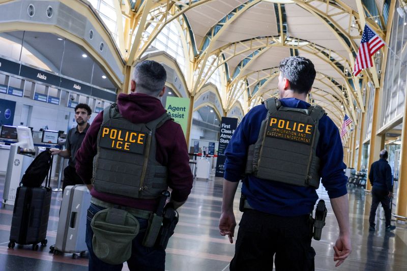 FILE PHOTO: U.S. Immigration and Customs Enforcement (ICE) agents patrol at Washington Reagan National Airport in Arlington, Virginia, U.S., March 24, 2026. REUTERS/Jonathan Ernst/File Photo