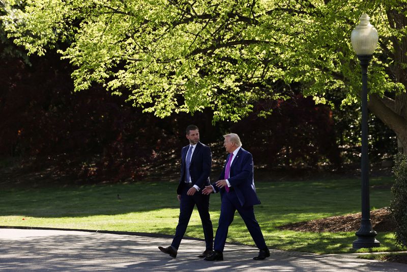 U.S. President Donald Trump speaks to Eric Trump as they walk together to depart the White House in Washington, D.C., U.S., April 10, 2026. REUTERS/Anna Rose Layden