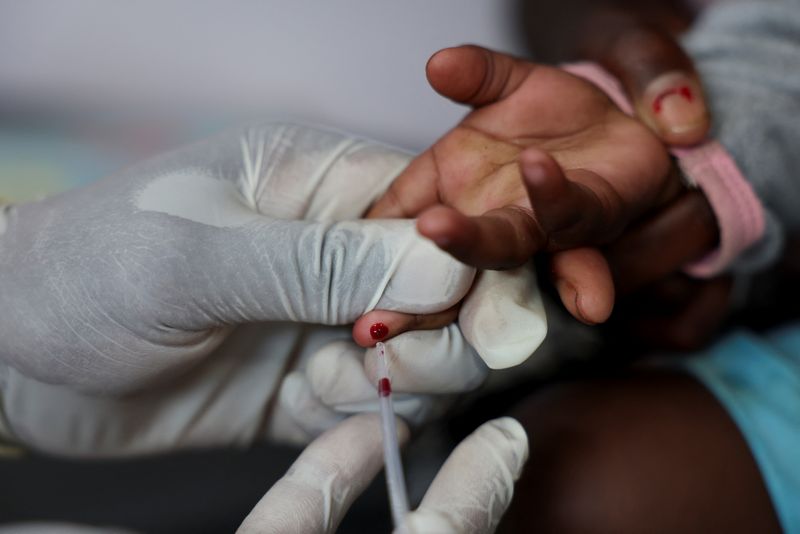 A nurse draws a blood sample from a child for an HIV test at a clinic in Diepsloot, north of Johannesburg, South Africa, March 12, 2025. REUTERS/Siphiwe Sibeko/File Photo