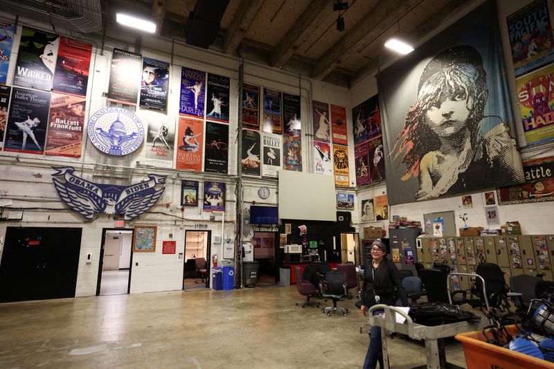 A worker stands amid posters from various performances backstage at the John F. Kennedy Memorial Center for the Performing Arts, renamed The Donald J. Trump and The John F. Kennedy Memorial Center for the Performing Arts, by the Trump administration, in Washington, D.C., U.S., April 22, 2026. REUTERS/Kevin Lamarque