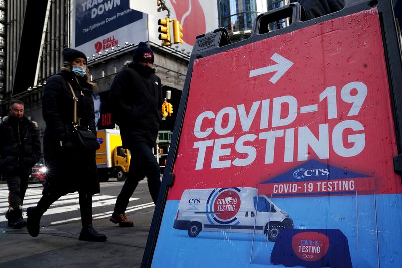 FILE PHOTO: People walk past a COVID-19 testing sign during the coronavirus disease (COVID-19) pandemic in the Manhattan borough of New York City, New York, U.S., January 20, 2022. REUTERS/Carlo Allegri/File Photo