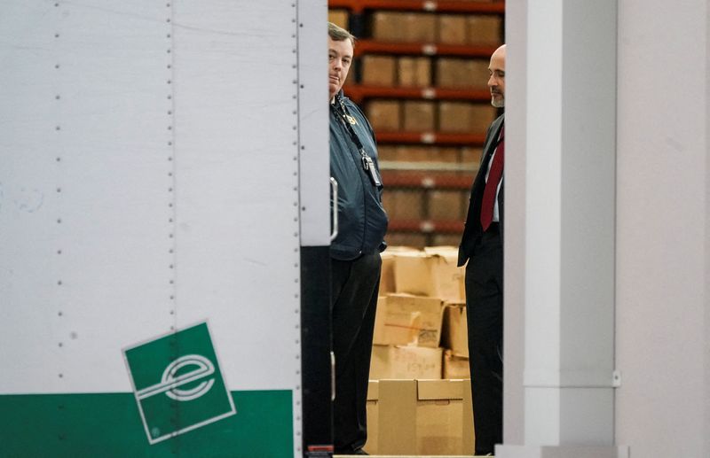 FILE PHOTO: Members of the Federal Bureau of Investigation (FBI) stand inside a vehicle loaded with boxes outside the Fulton County Election Hub and Operation Center after the FBI executed a search warrant there in relation to the 2020 election, according to a law enforcement official familiar with the matter, in Union City, Georgia, U.S. January 28, 2026.  REUTERS/Elijah Nouvelage/File Photo