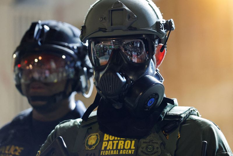 FILE PHOTO: A Border Patrol agent stands guard as people gather outside the U.S. Immigration and Customs Enforcement (ICE) facility, in Portland, Oregon, March 28, 2026. REUTERS/John Rudoff/File Photo